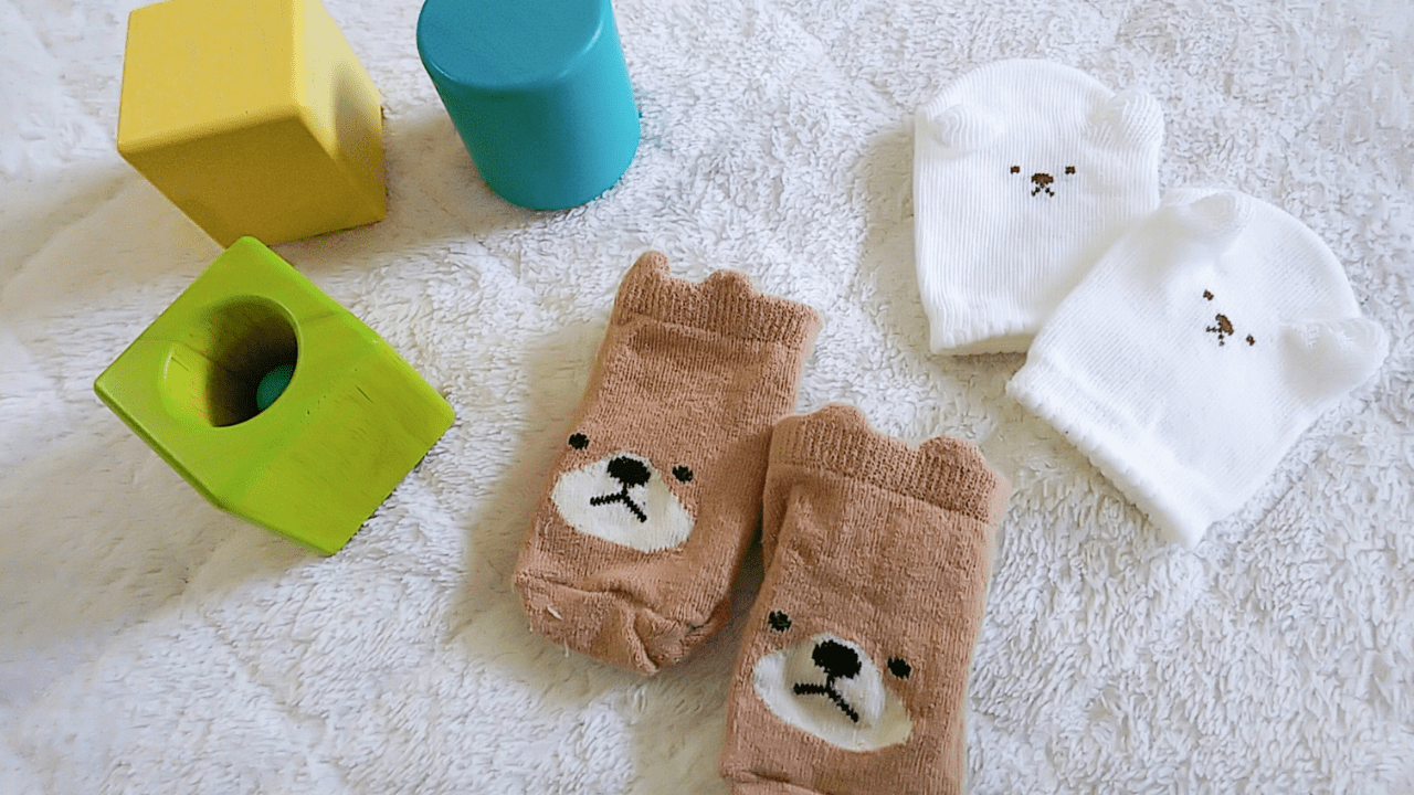 出産祝いをイメージした、積み木、くまの靴下、ミトン