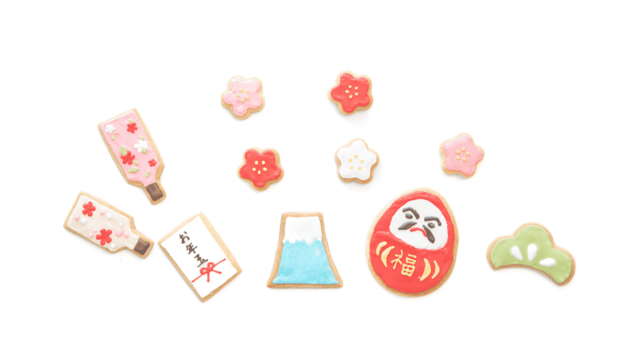 白背景に並んだ、お年玉・だるま・富士山・桜などのお正月モチーフのアイシングクッキー